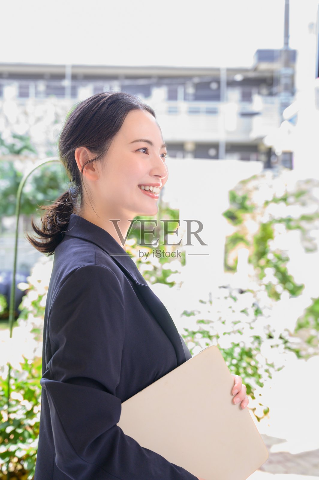 一位日本女性在办公室里微笑着使用电脑照片摄影图片