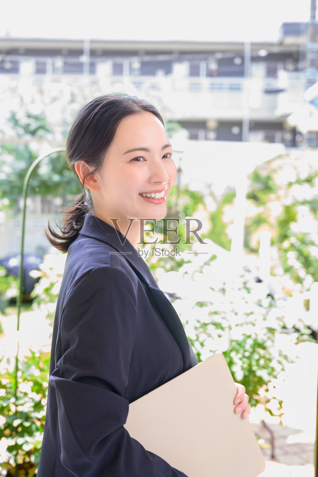 一位日本女性在办公室里微笑着使用电脑照片摄影图片