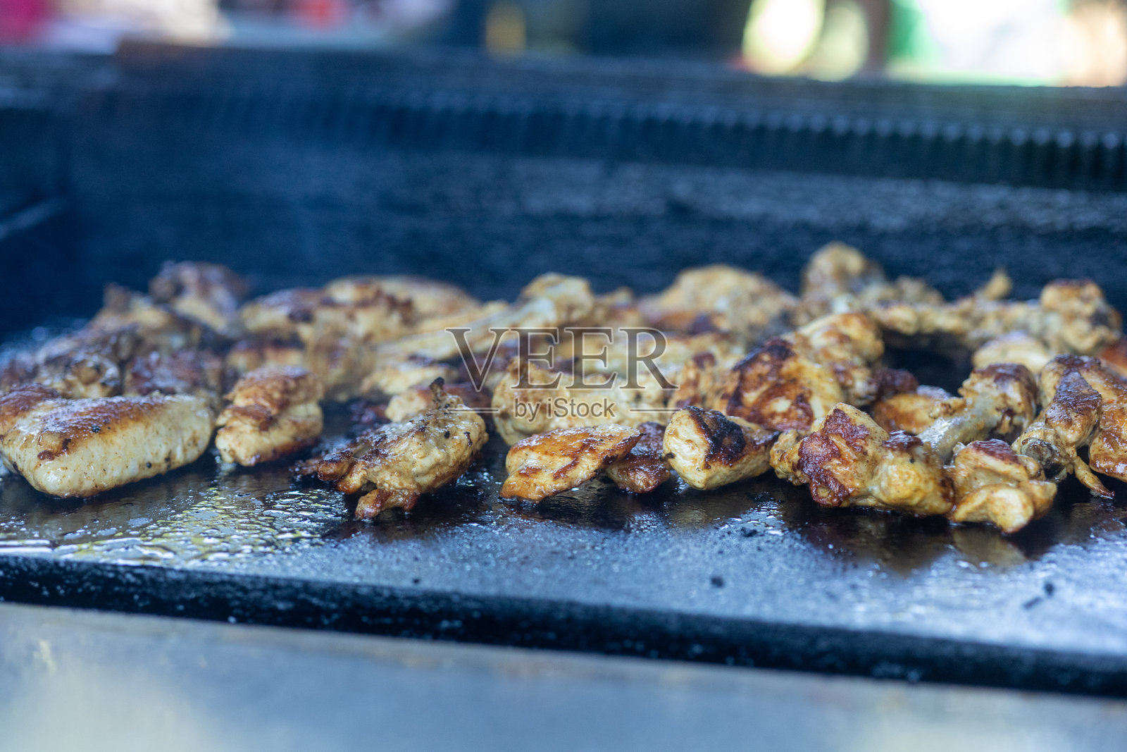 鸡翅、肉类和蔬菜在大型烧烤桌上烤制照片摄影图片