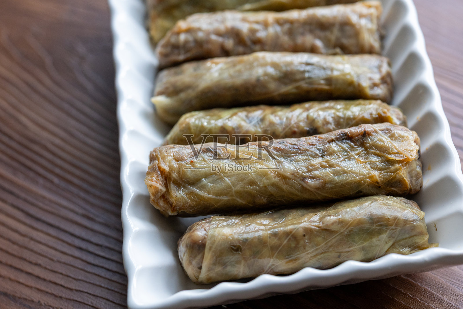 方形盘子里的土耳其式卷心菜卷放在棕色桌子上照片摄影图片