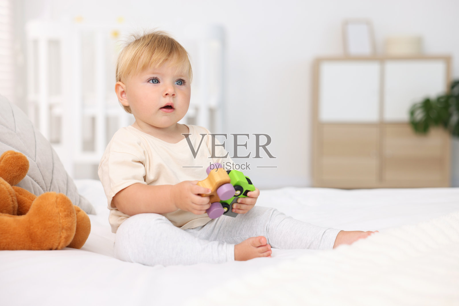 可爱的小宝宝在房间的床上玩玩具，留有文字空间照片摄影图片