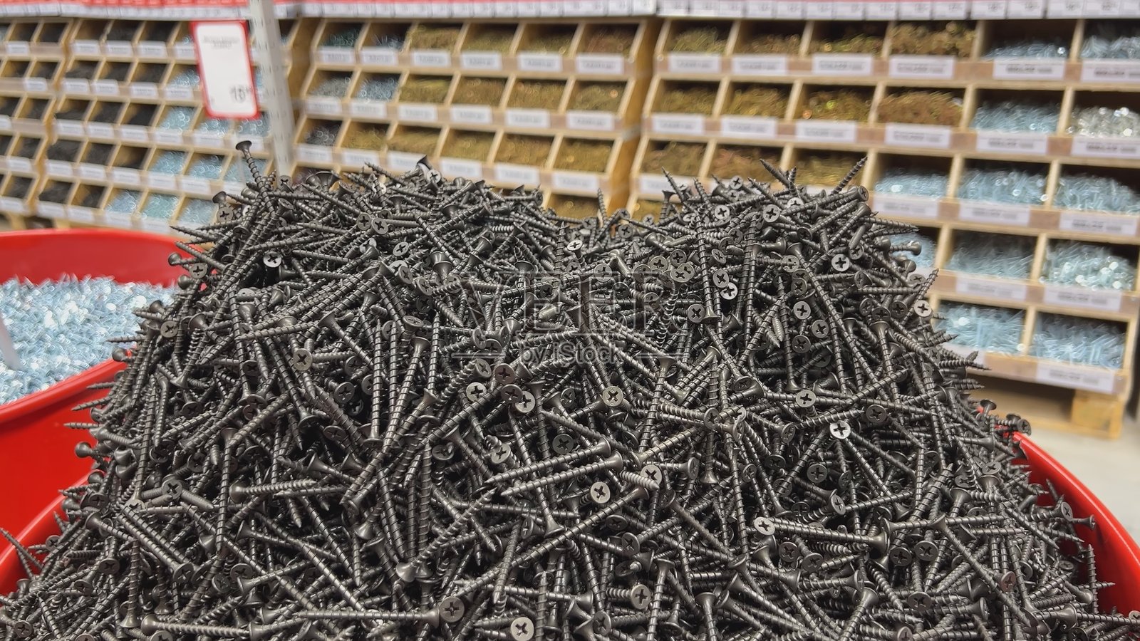 商店柜台上摆放的黑色自攻螺丝。照片摄影图片