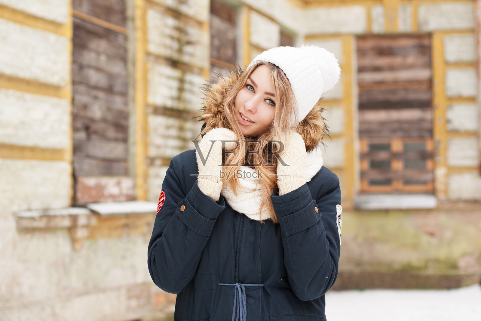 一个可爱的女孩在老砖墙旁微笑，户外肖像。照片摄影图片