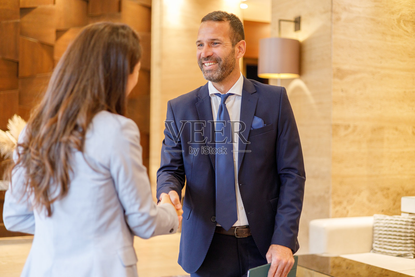 一位男商人和一位女士正在握手，象征着成功的协议和职业人脉拓展照片摄影图片