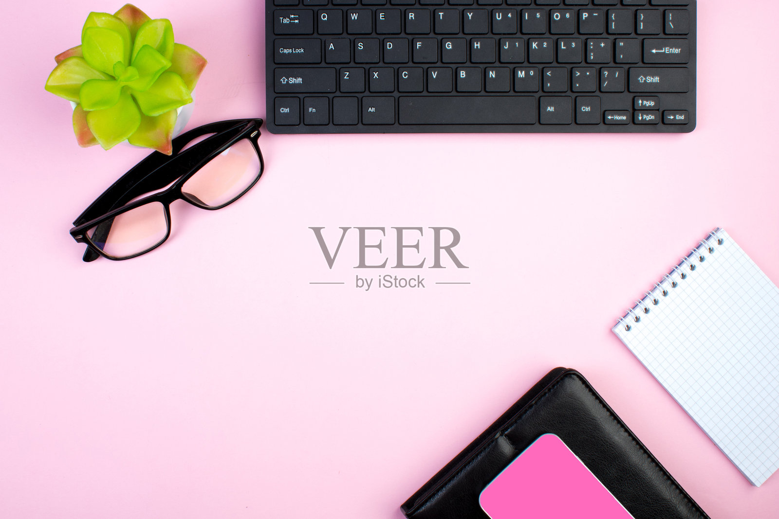 粉色办公桌，上面放着电脑、钢笔和咖啡杯，物品很多。俯视角度，留有复制空间。照片摄影图片