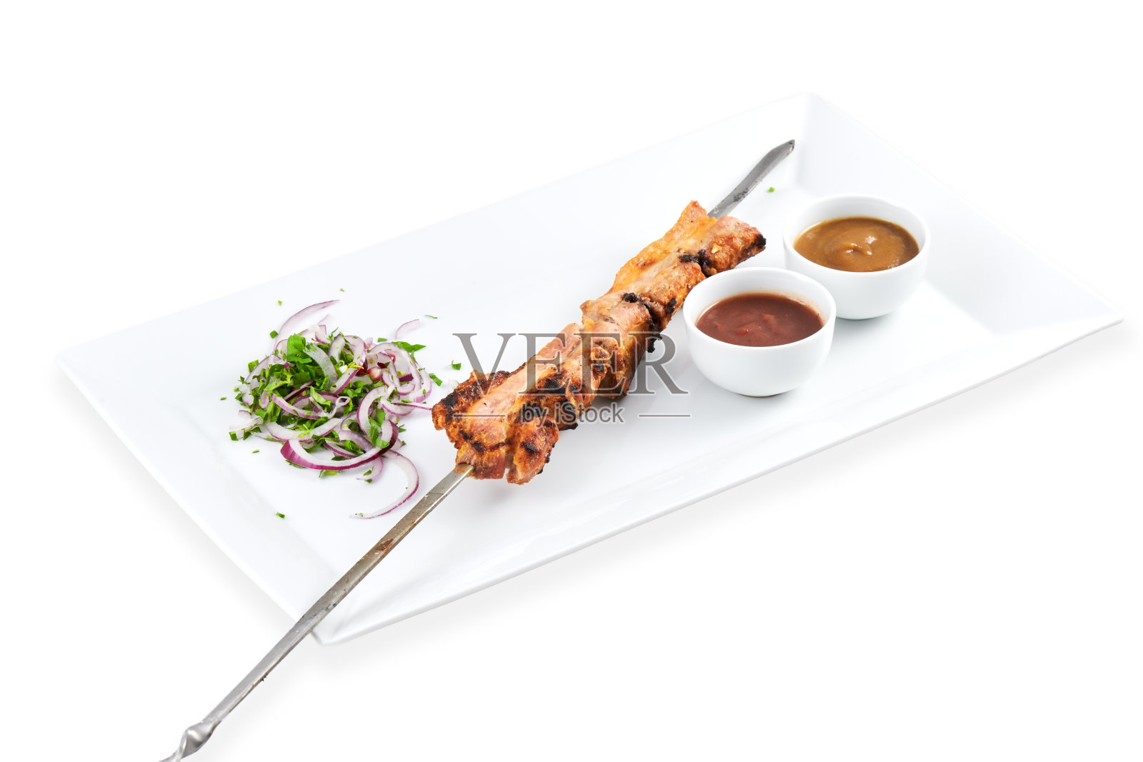 烤鸡肉串配酱汁和新鲜蔬菜，盛放在白色盘子上照片摄影图片
