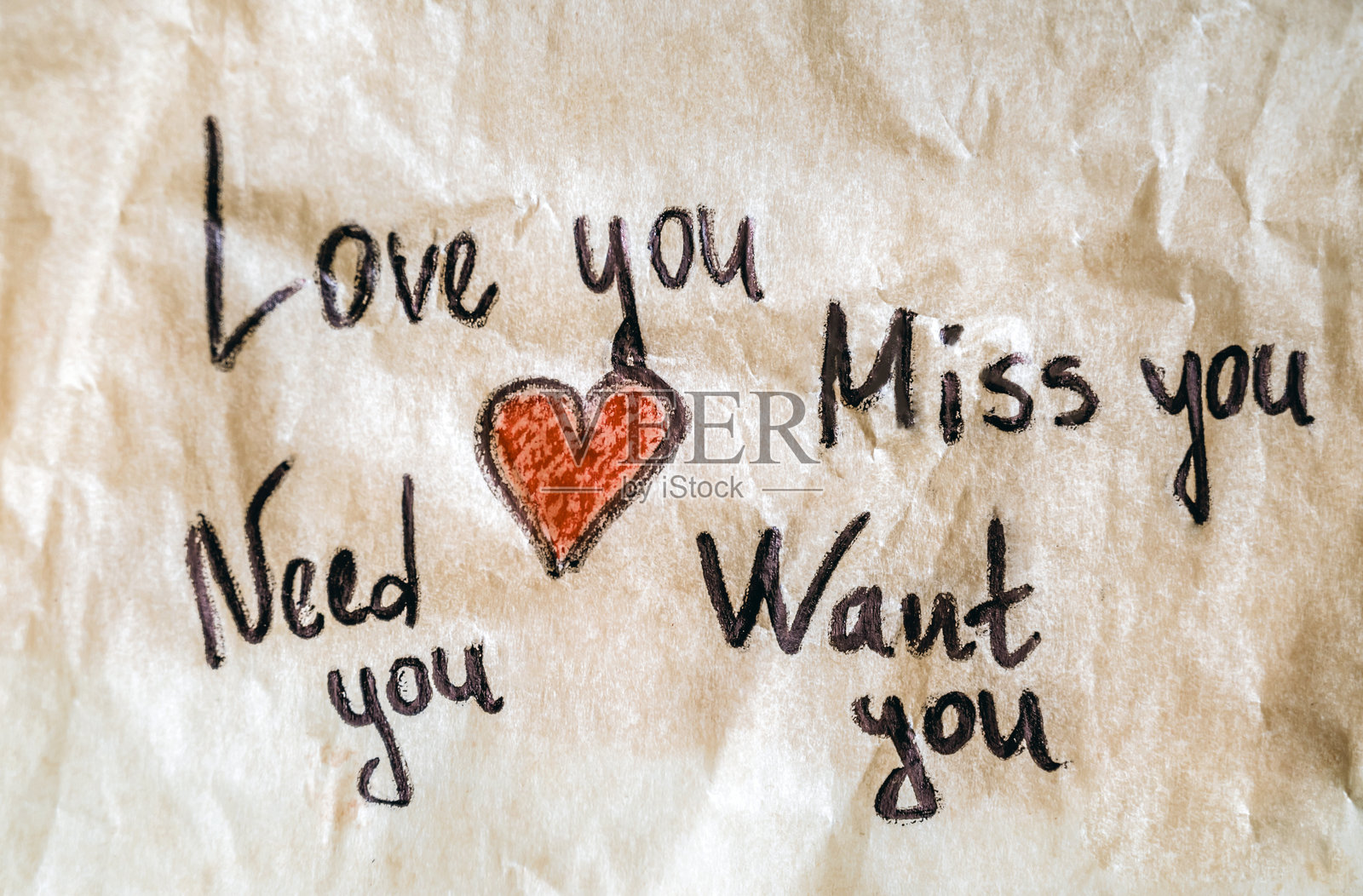 揉皱的纸上写着“爱你，想你”的字样照片摄影图片