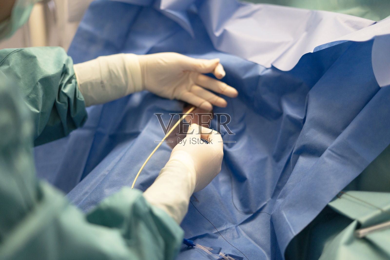 外科医生在手术室使用导管进行医疗手术照片摄影图片