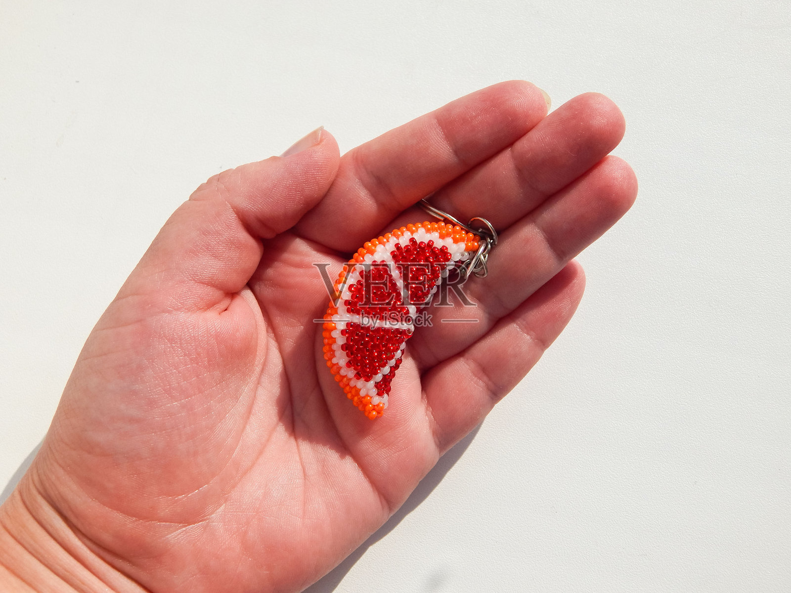 橙子造型的钥匙扣放在女士的手掌上照片摄影图片