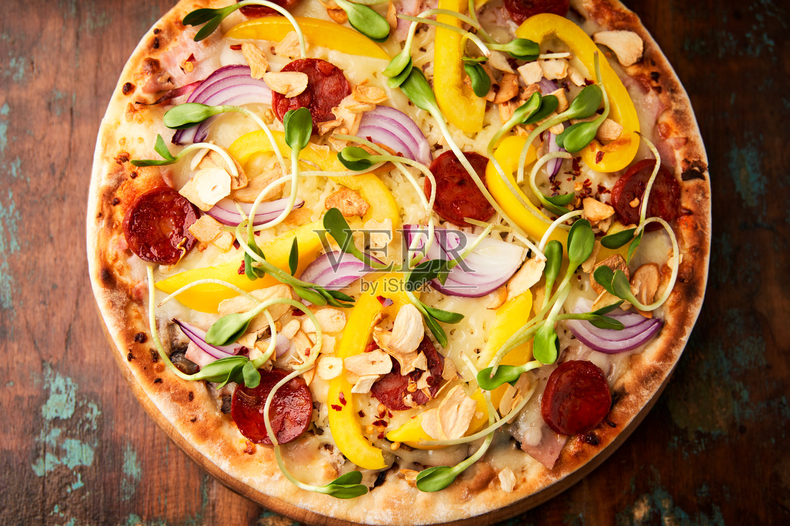 披萨配有乔利佐香肠、马苏里拉奶酪和黄甜椒。乡村木质背景。柔焦。照片摄影图片