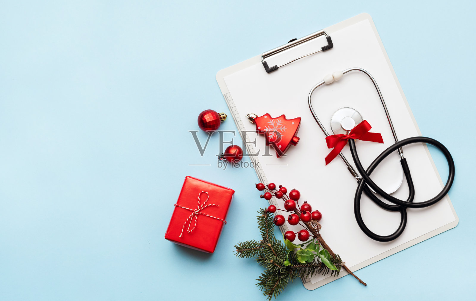 听诊器、空白剪贴板和圣诞装饰品。医疗概念。照片摄影图片