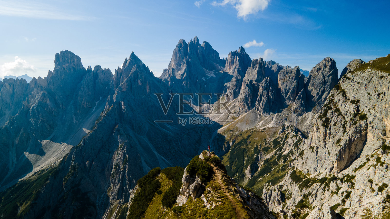 徒步者在多洛米蒂山脉的戏剧性尖峰之上，位于山脊线上照片摄影图片