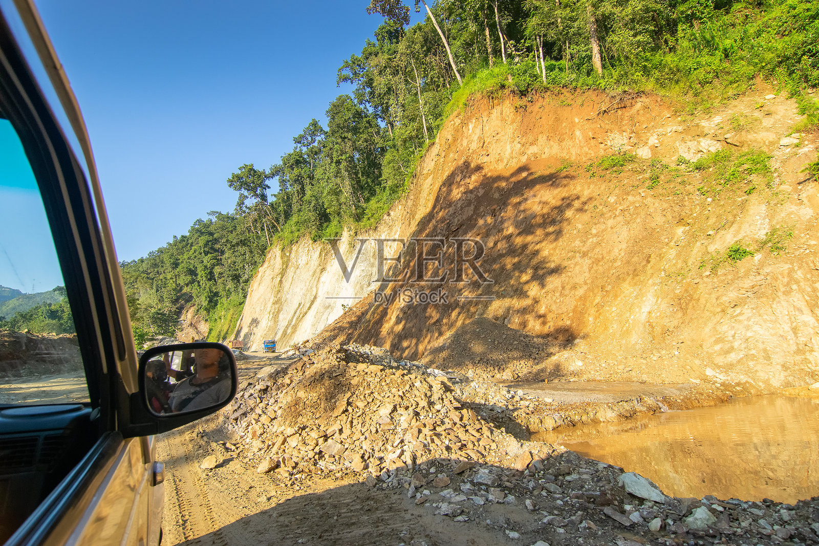 一辆汽车在喜马拉雅山脉山体滑坡后，在锡金的道路上行驶，该道路正在重建中。照片摄影图片