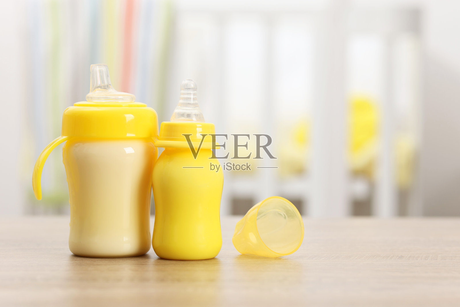 木制桌上放着装有牛奶的奶瓶照片摄影图片