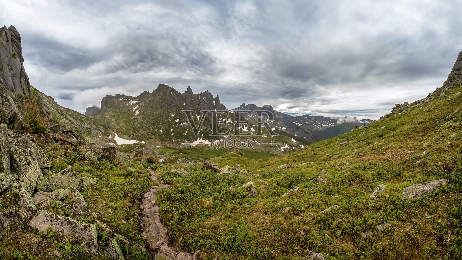 穿过绿色石质高原的徒步小径照片摄影图片