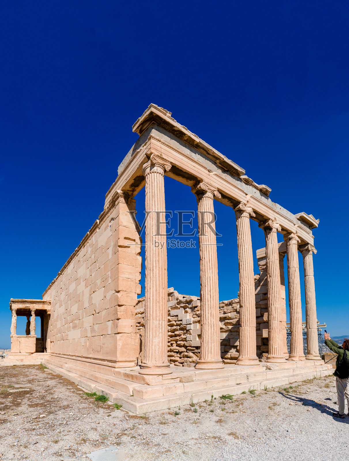 希腊雅典卫城标志性的埃雷赫修神庙，拥有爱奥尼式廊柱和女像柱门廊，背景是深邃的蓝天。照片摄影图片