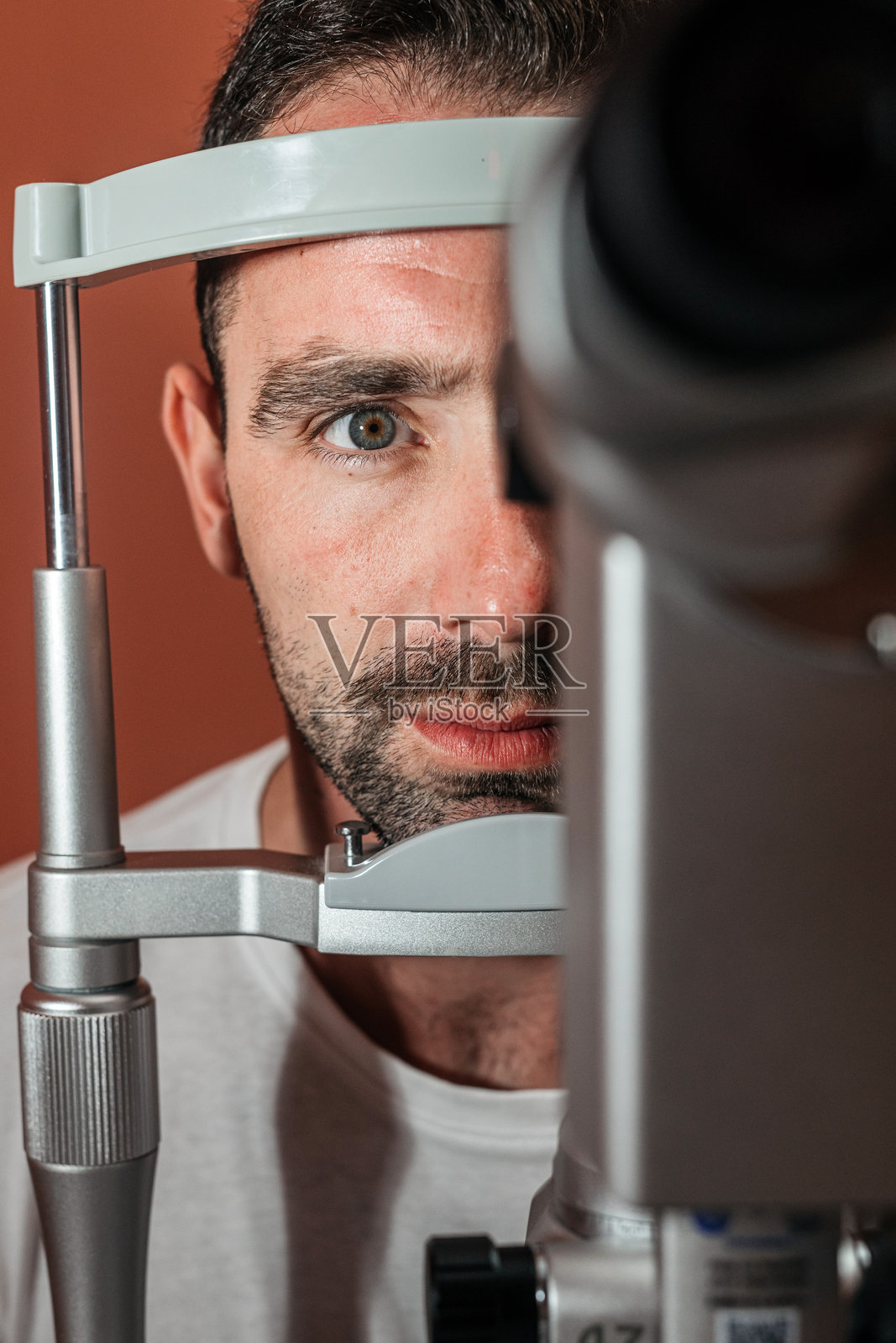 一名男性患者正在使用裂隙灯设备接受详细的视力检查照片摄影图片