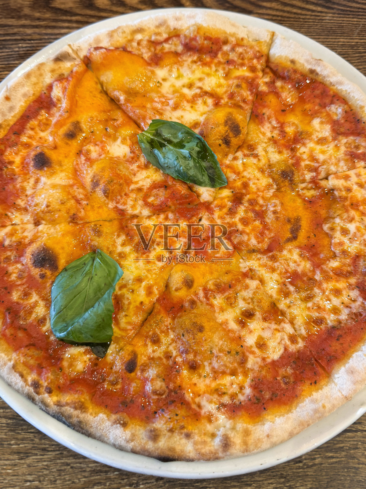 俯视木烤玛格丽特披萨/烤意大利披萨，配马苏里拉奶酪和新鲜罗勒叶照片摄影图片