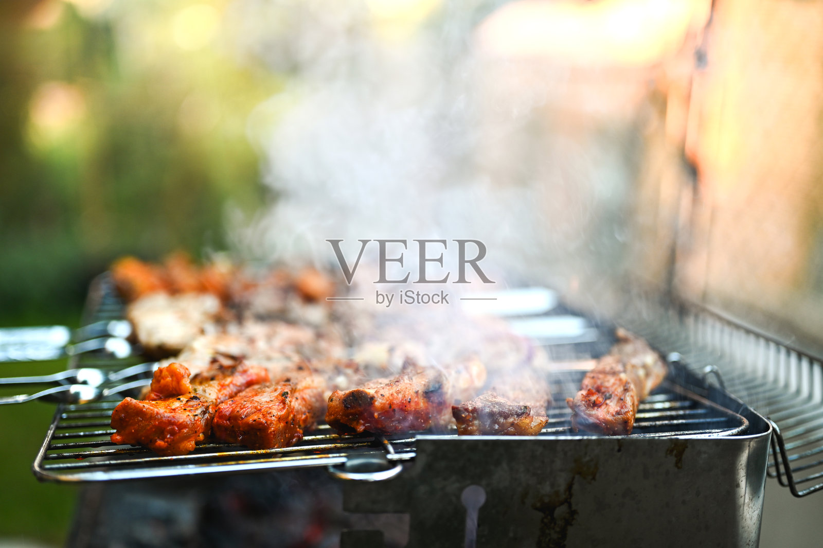 烧烤架上烤肉冒着烟照片摄影图片