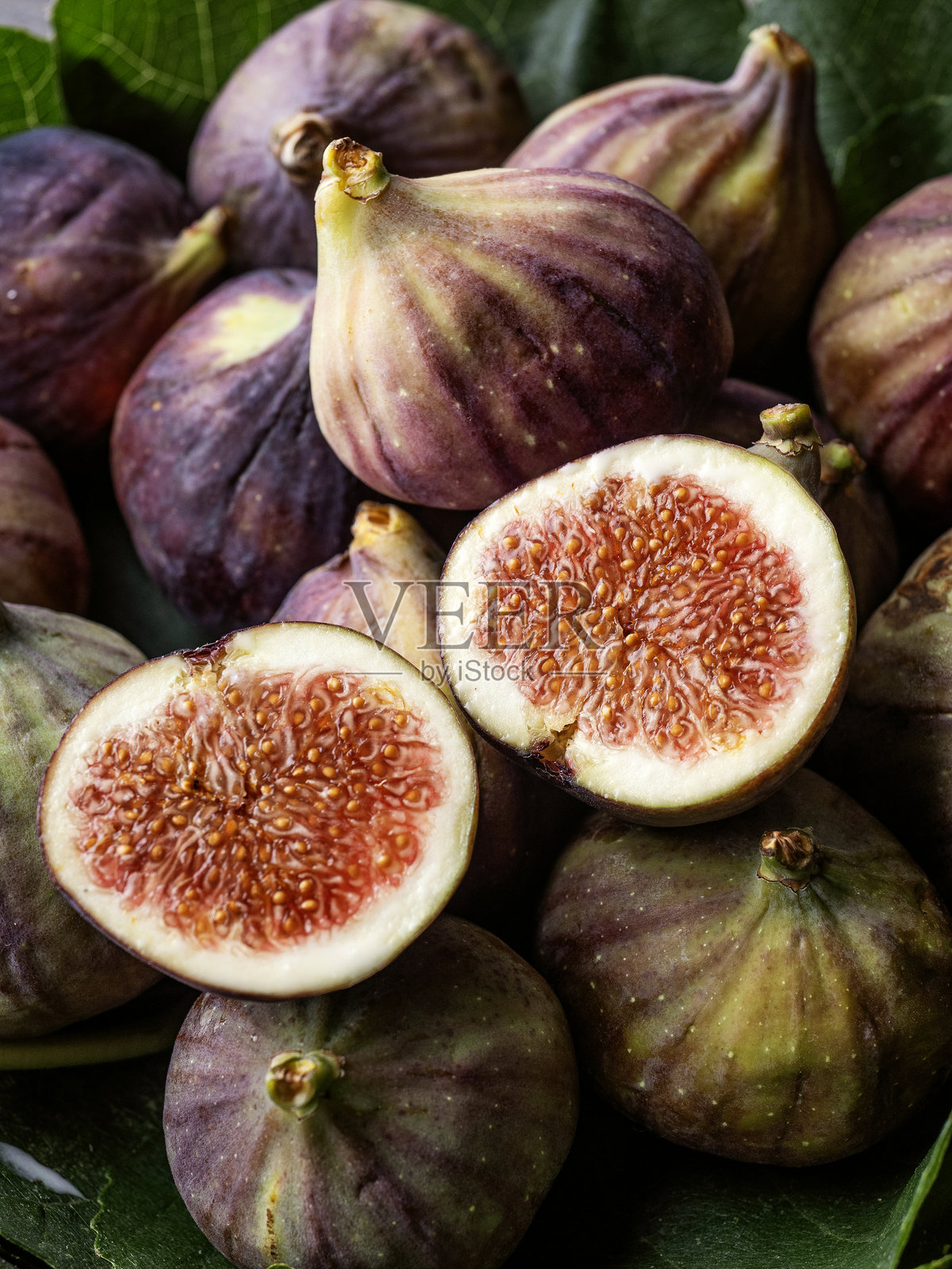 新鲜无花果果实和切片，背景。无花果特写摄影。新鲜无花果对半切开照片摄影图片