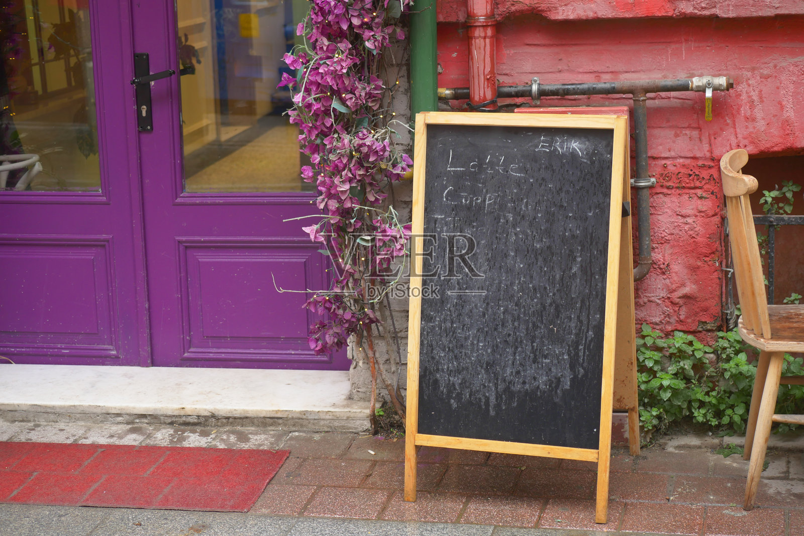 一家色彩缤纷的咖啡馆外摆放着一块写有菜单的黑板架照片摄影图片