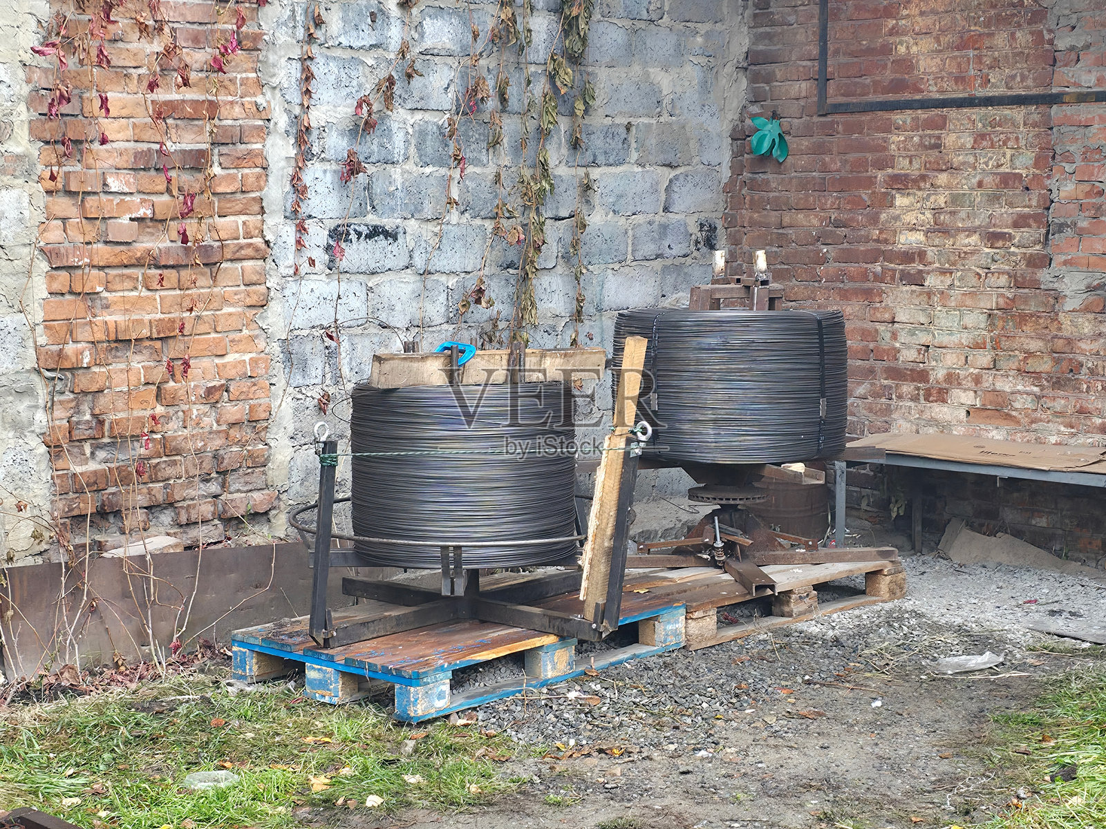 钢丝卷存放在砖墙附近照片摄影图片