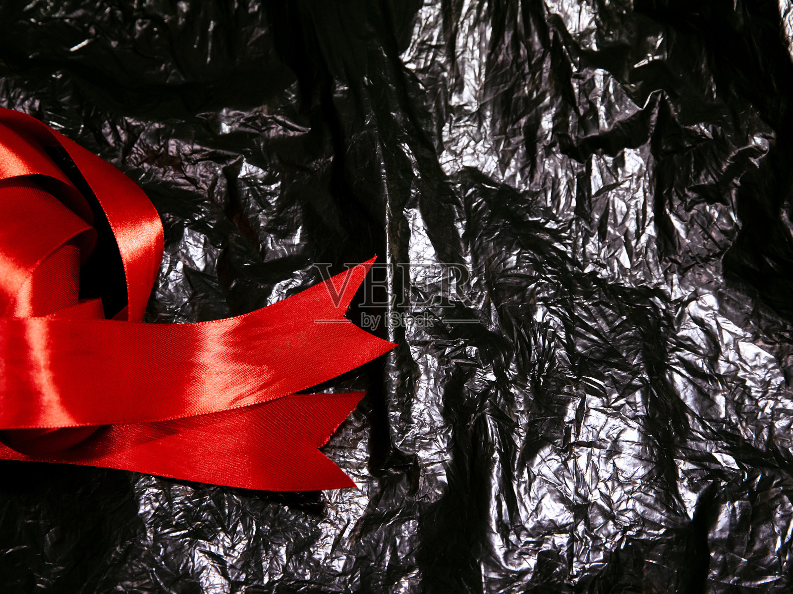 粗犷的红色丝带横跨起皱的黑色背景照片摄影图片