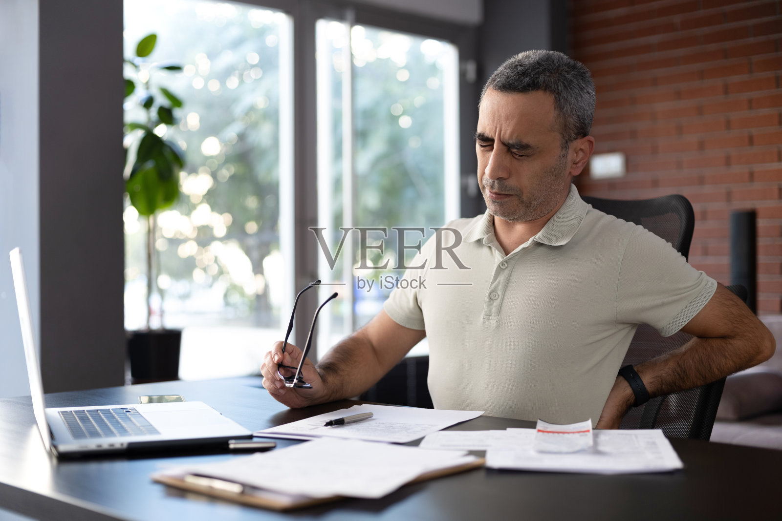 男人在办公室休息时间做运动，缓解脊柱疼痛照片摄影图片