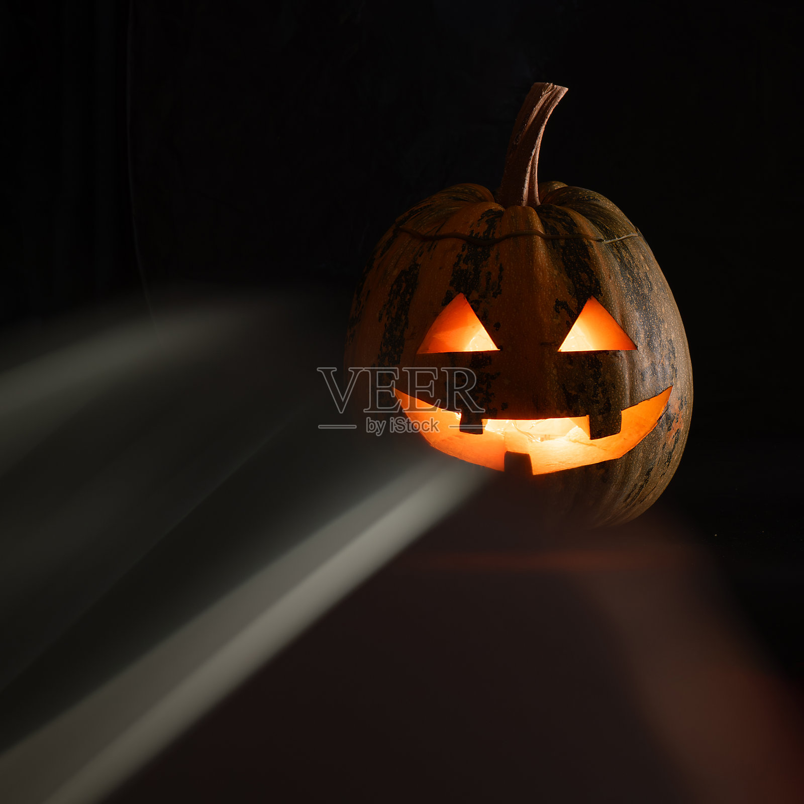 黑暗背景下冒着烟的闪亮杰克南瓜灯照片摄影图片