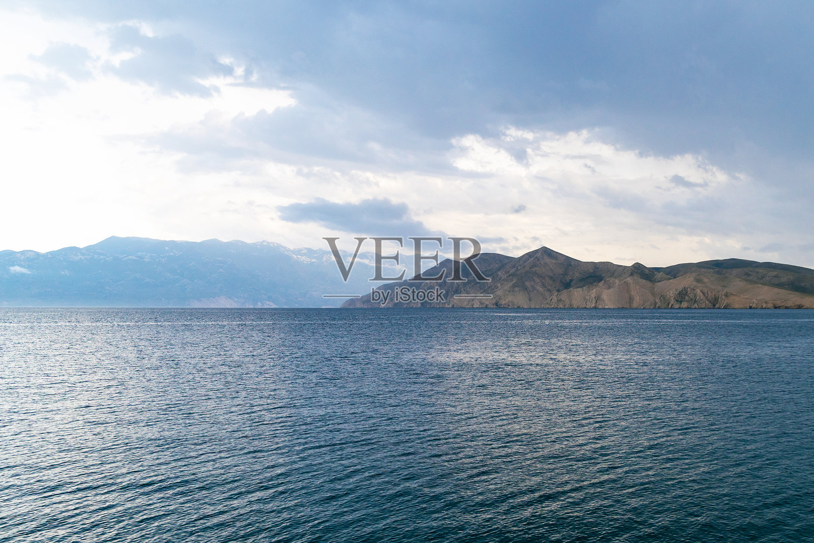 黄昏时宁静的海滨风光，海面平静，天空多云。克罗地亚普尔维奇岛的景色。照片摄影图片