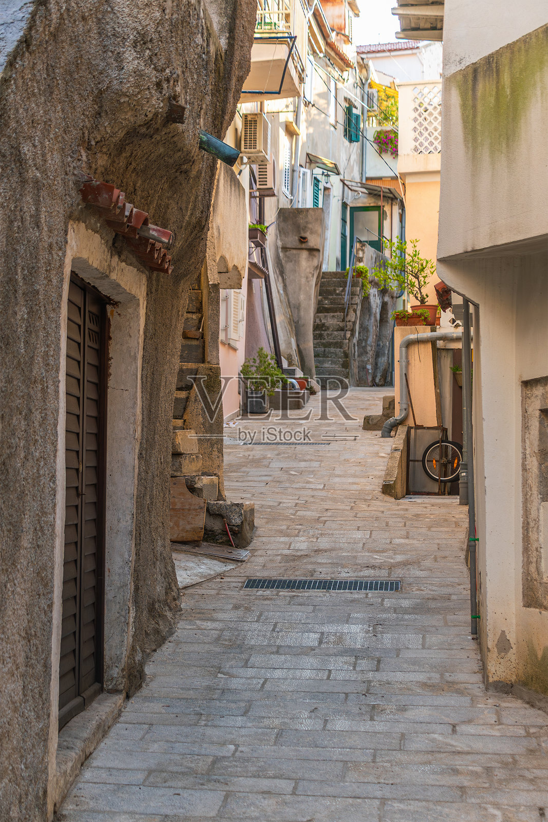 迷人的石头小巷，坐落于古朴的欧洲村庄，拥有质朴的建筑。地点：巴什卡，克尔克岛，克罗地亚照片摄影图片