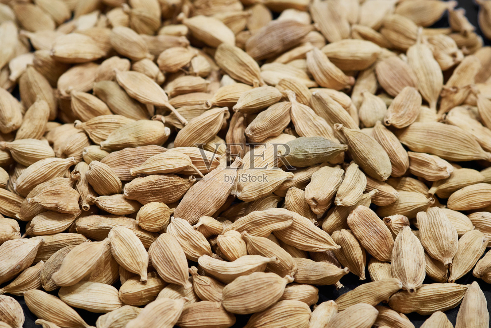 散落堆积的整颗干豆蔻豆荚的宏观特写，芳香香料的近景照片摄影图片
