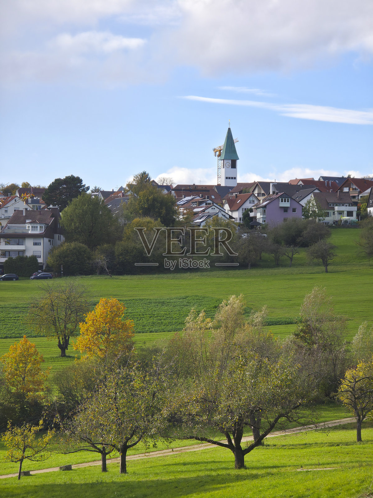 德国，奥斯特菲尔登肯马特村庄房屋教堂尖顶天际线，秋季日落时分绿色的自然风光，树梢之上视野开阔照片摄影图片