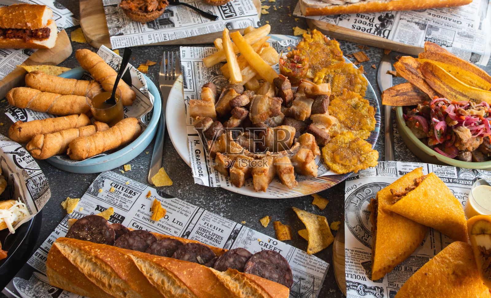 包括墨西哥玉米粉蒸肉、炸芭蕉和香肠在内的各种拉丁美洲菜肴。照片摄影图片