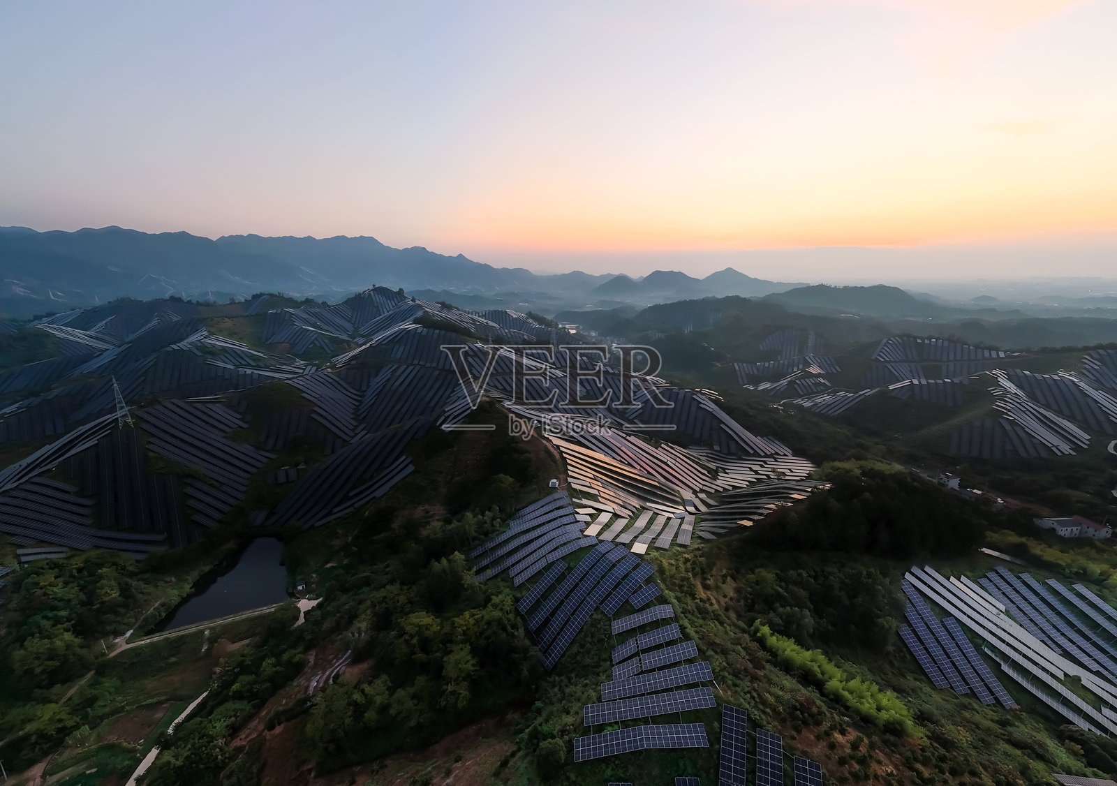 日落时分山坡上的太阳能电池板照片摄影图片
