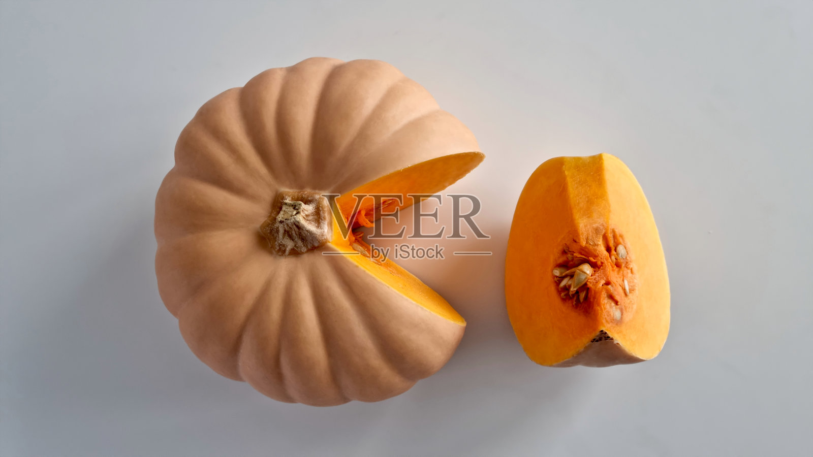 一个创意极简主义构图，以一个镂空南瓜为特色，其造型令人联想到一款著名复古电子游戏中的角色。照片摄影图片