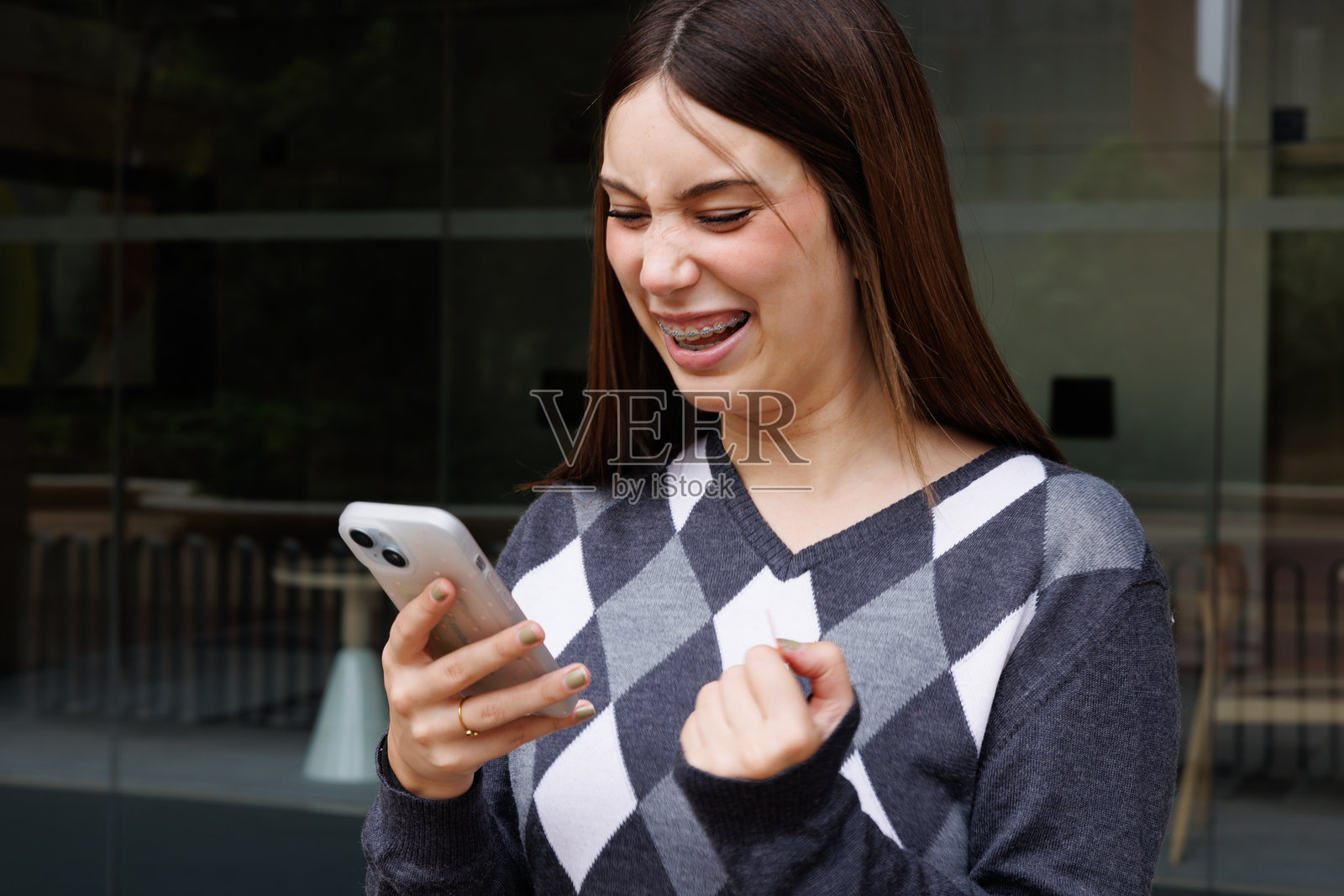 一位年轻的休闲女子独自走在巴塞罗那街头，自信地微笑着看向镜头，适合商业用途的生活方式素材摄影。照片摄影图片