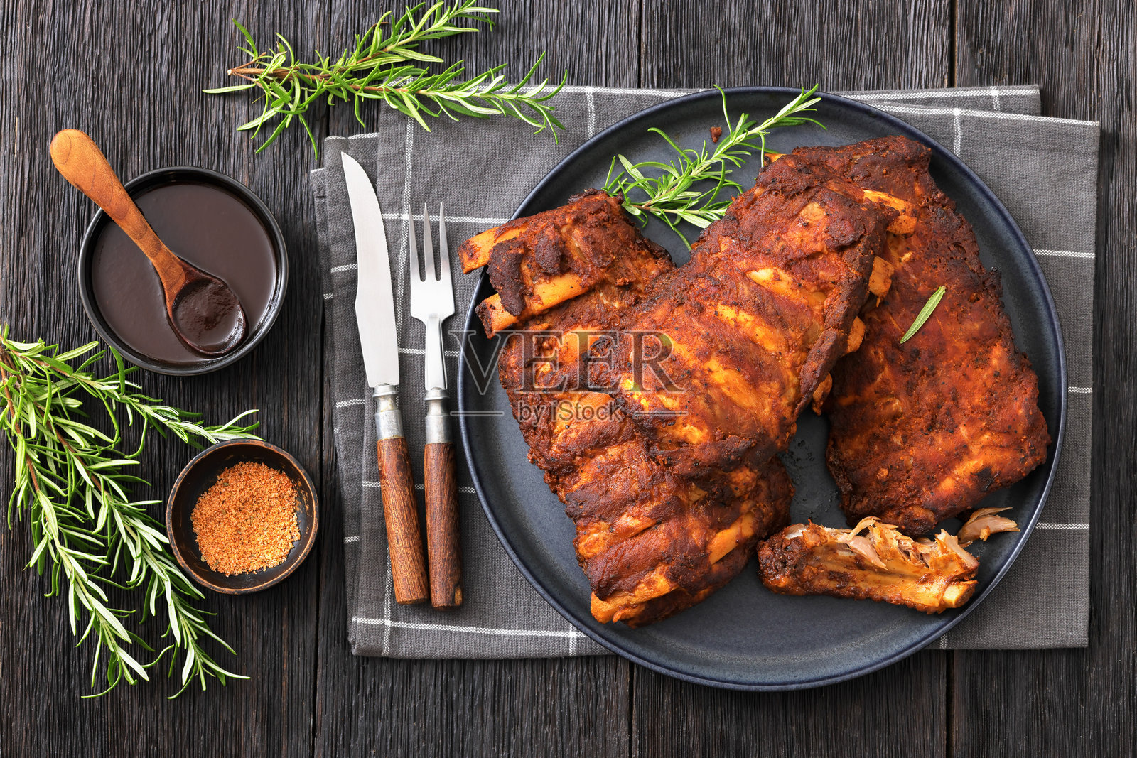 烤猪肋排配新鲜迷迭香放在盘子里照片摄影图片