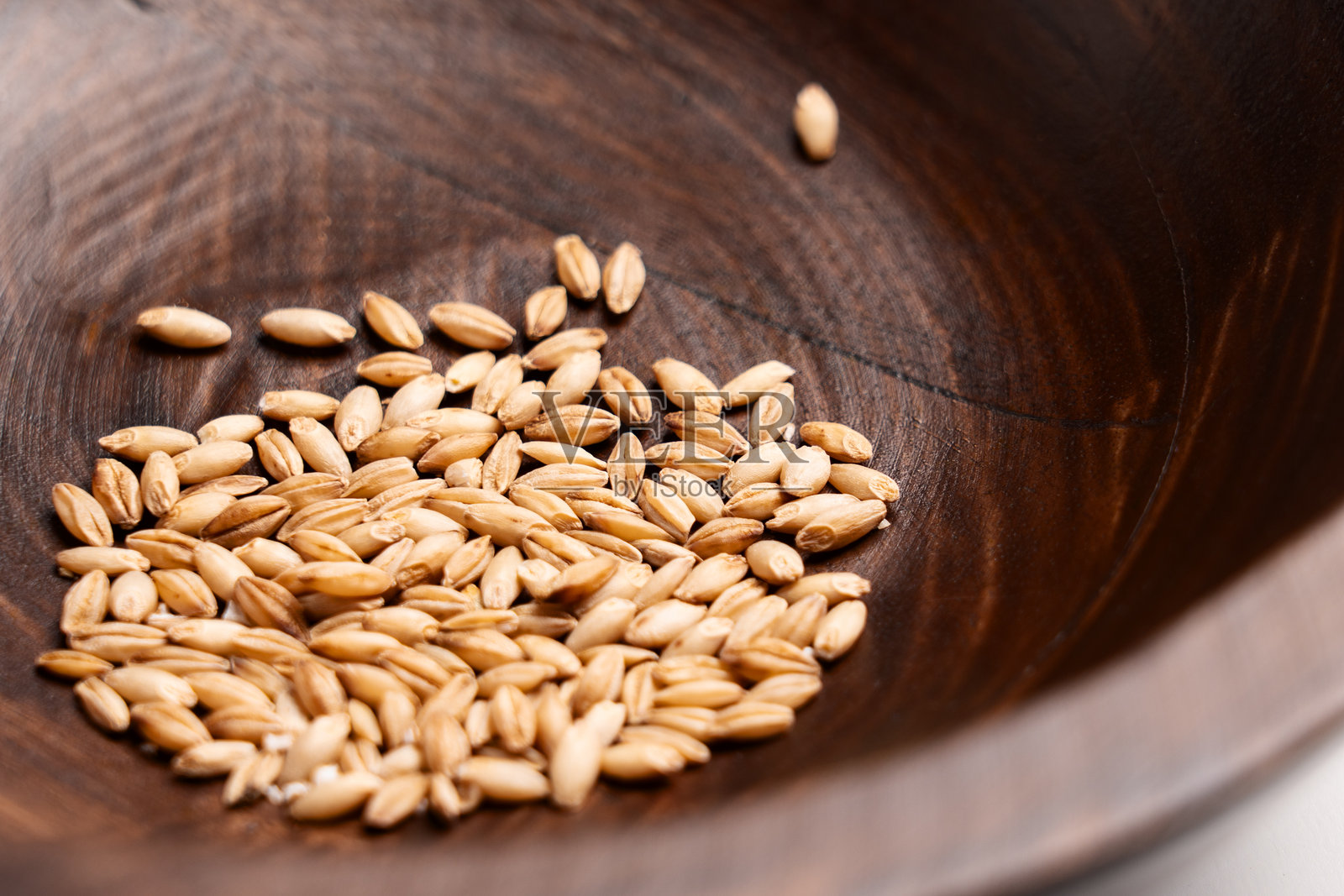 猫草生谷粒放在木碗纹理上照片摄影图片