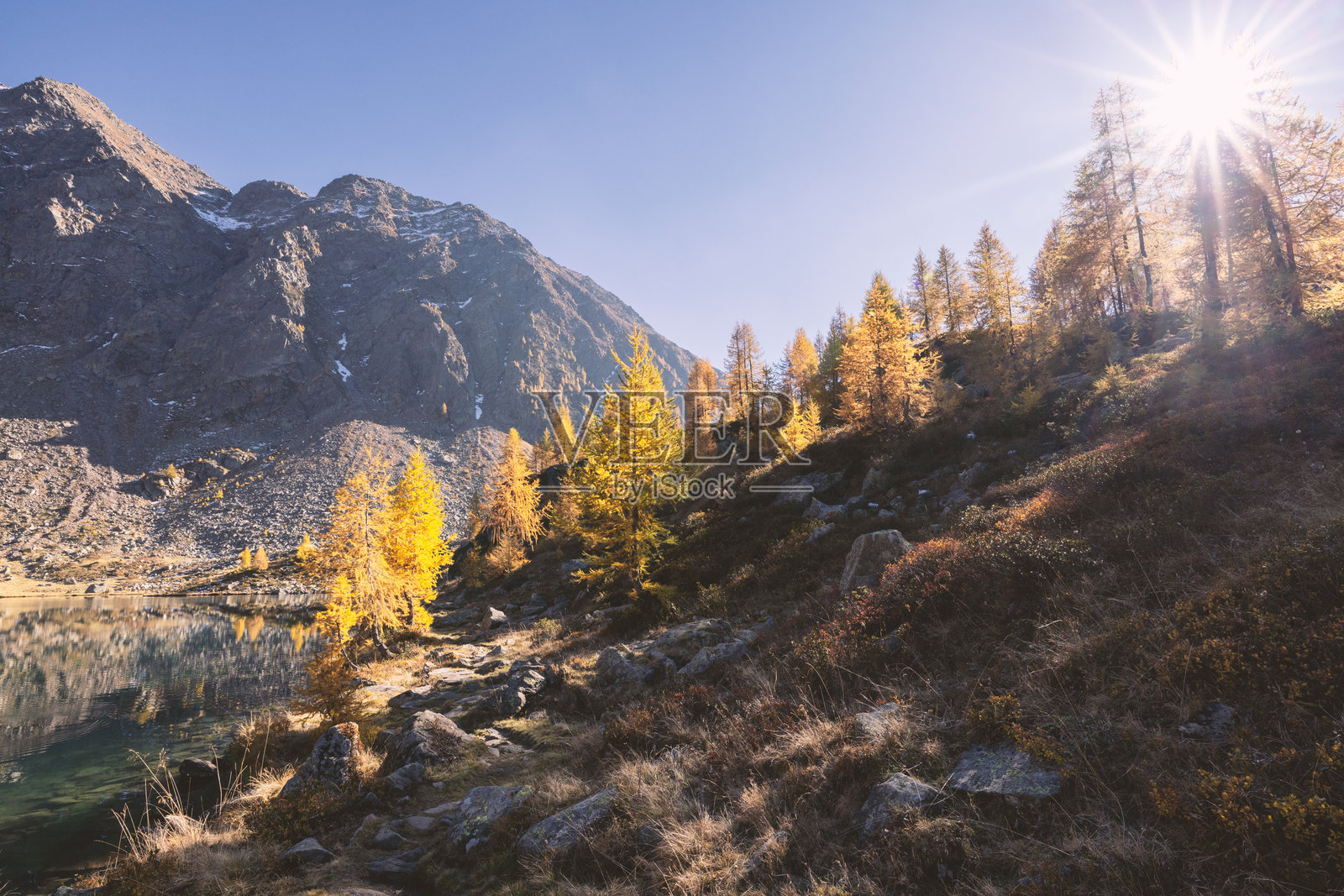 秋日阳光照耀在山间湖畔小径上照片摄影图片