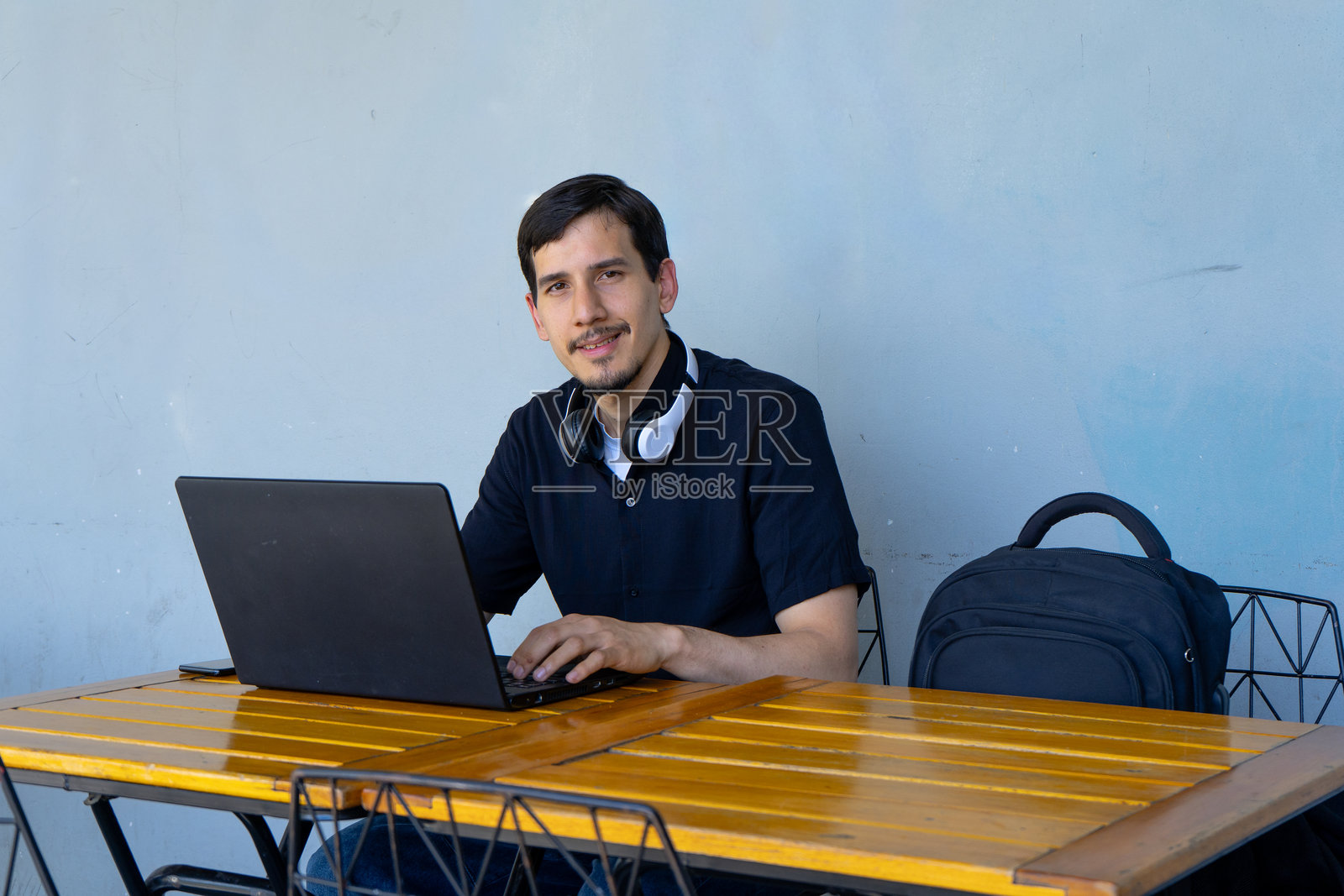 年轻男子使用笔记本电脑进行远程办公照片摄影图片