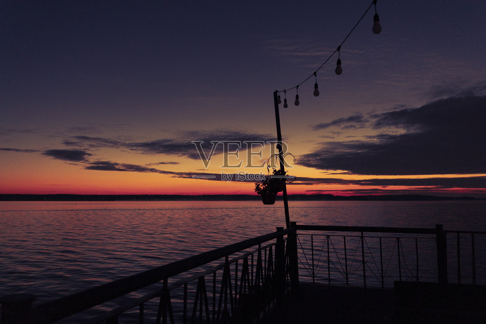 秋日晨曦中，湖边码头美景，剪影黝黑。照片摄影图片