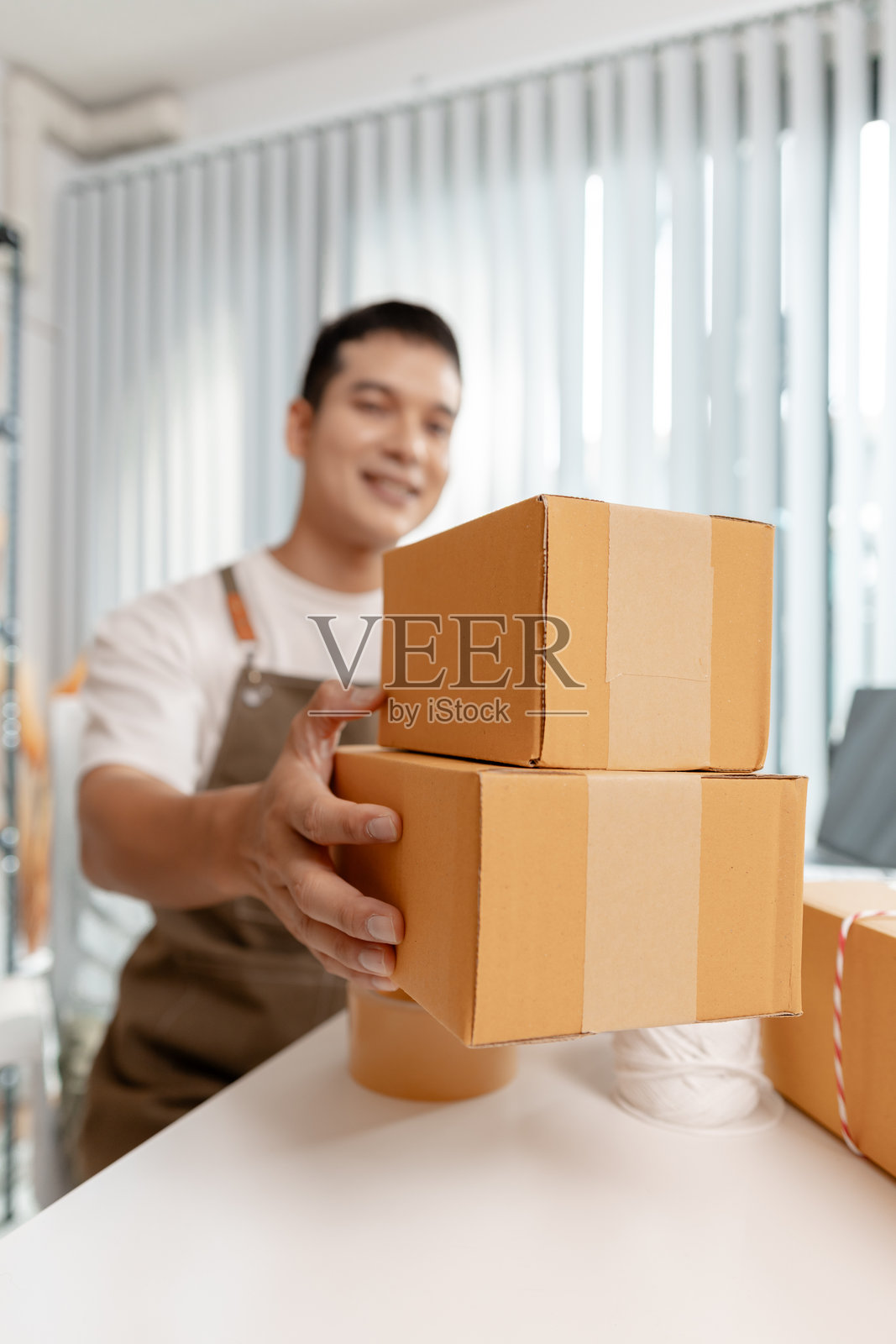 年轻企业家管理在线业务，准备包裹并处理电子商务运营，代表数字市场、初创企业增长和现代零售战略。照片摄影图片