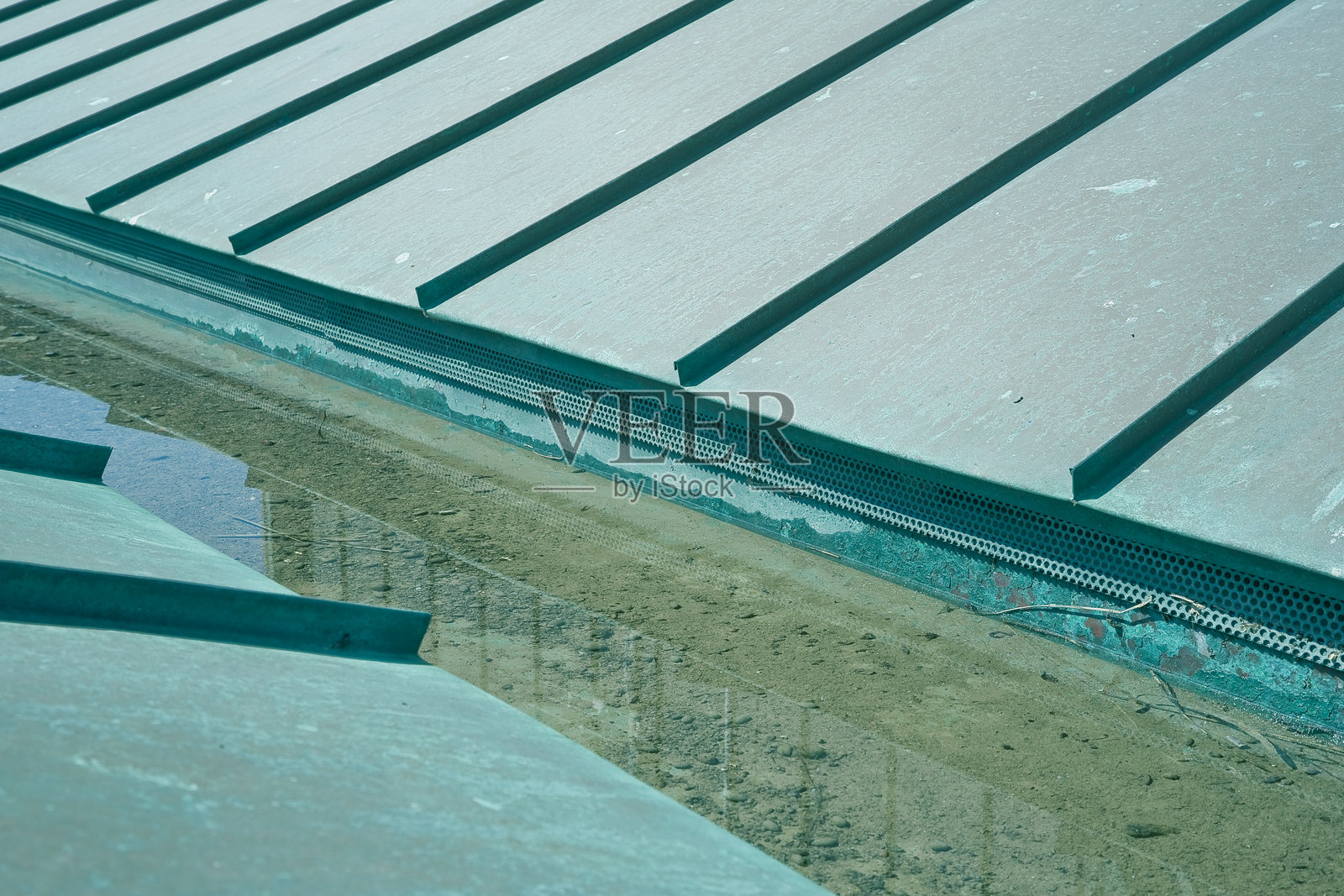 氧化后呈现绿色的铜制屋顶，带有雨水收集槽照片摄影图片