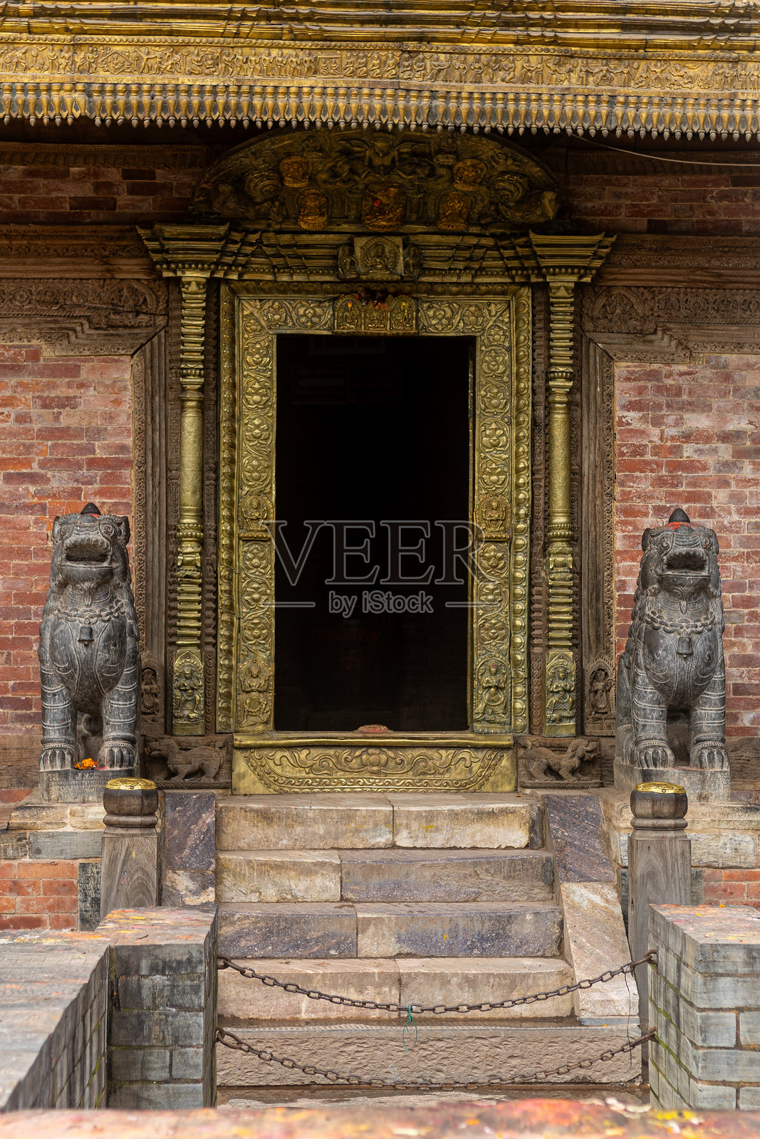 帕坦杜巴广场的宾森神庙入口，精美的尼瓦尔艺术和神圣的狮子守护者照片摄影图片