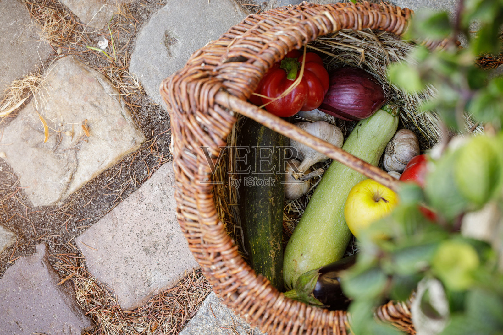 食物概念，特写，乡村风格的篮子，新鲜蔬菜，摆放在中欧街头广场的鹅卵石地面背景上，留有空间照片摄影图片