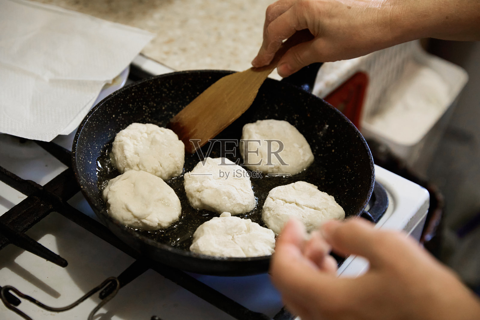 圣诞节临近，一位年长的主厨正在家中准备美味的煎饼照片摄影图片