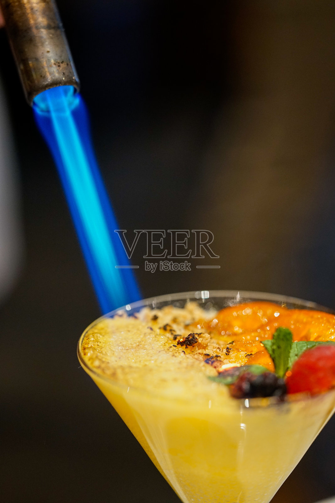 调酒师用喷枪为手工鸡尾酒焦糖化糖照片摄影图片