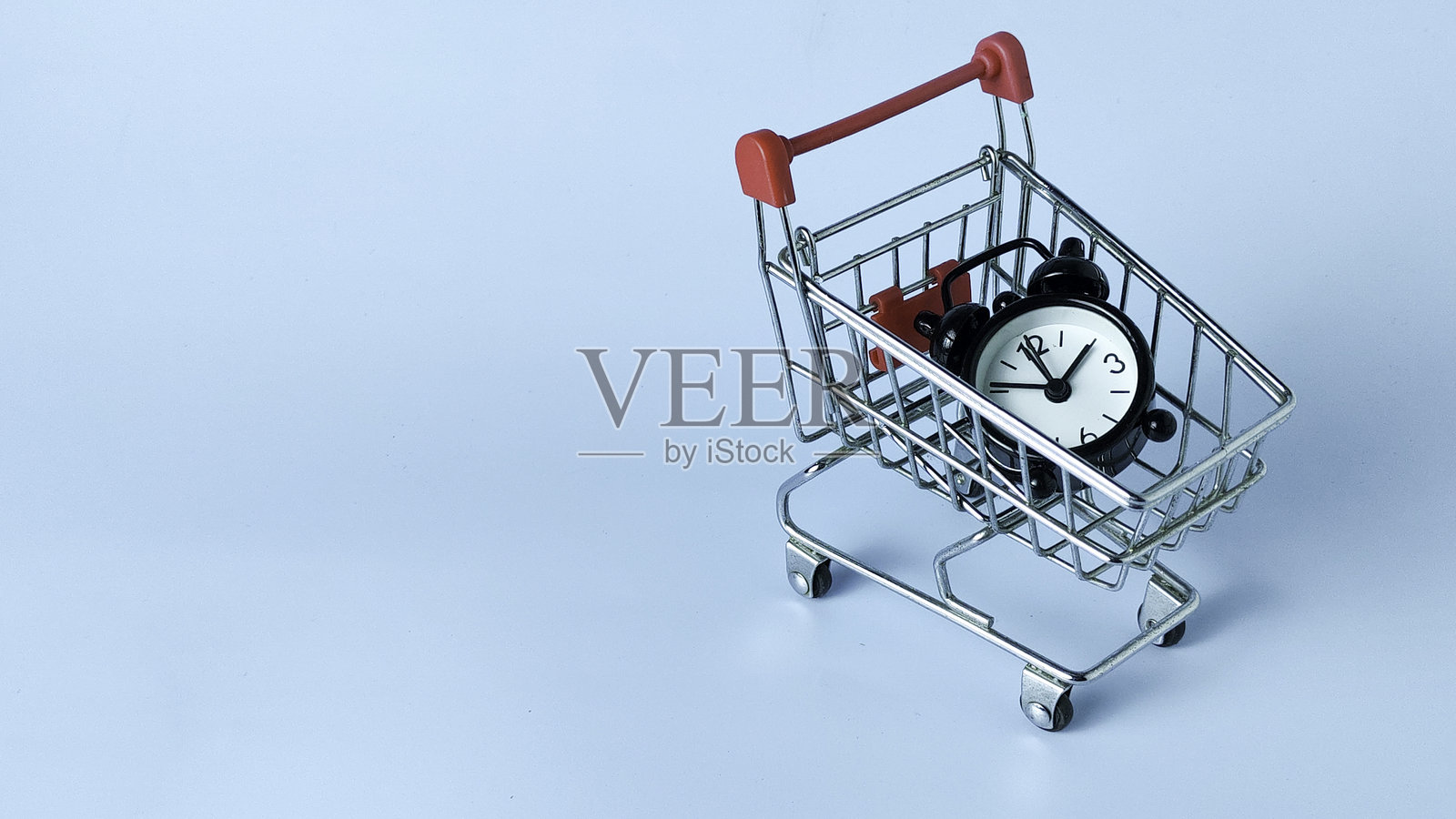 限时促销概念：带闹钟的迷你购物车照片摄影图片