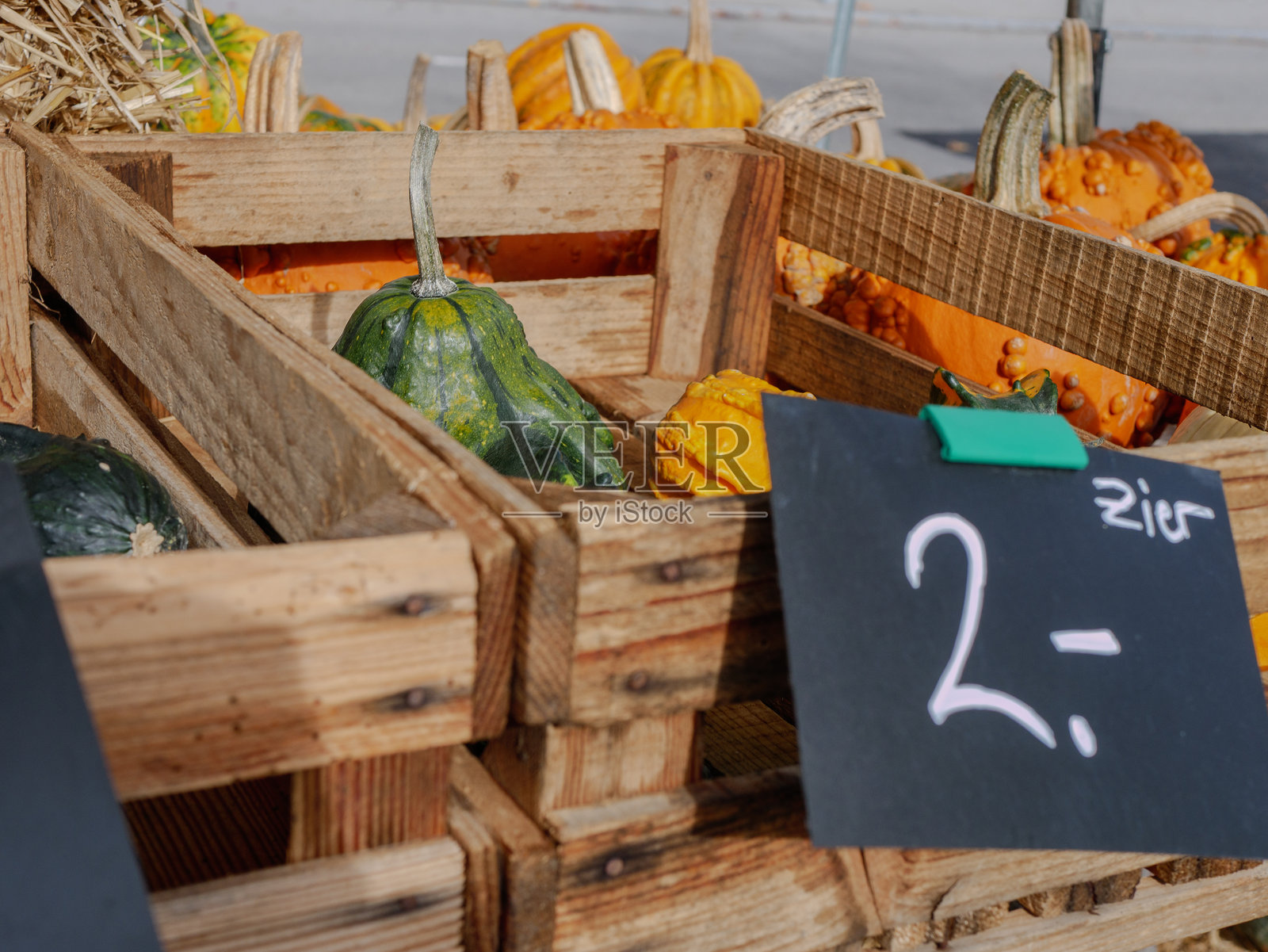 装有混合南瓜的木箱和粉笔价格牌捕捉到了农贸市场的活力，体现了生态价值、本地农产品和季节性秋季购物的瞬间照片摄影图片